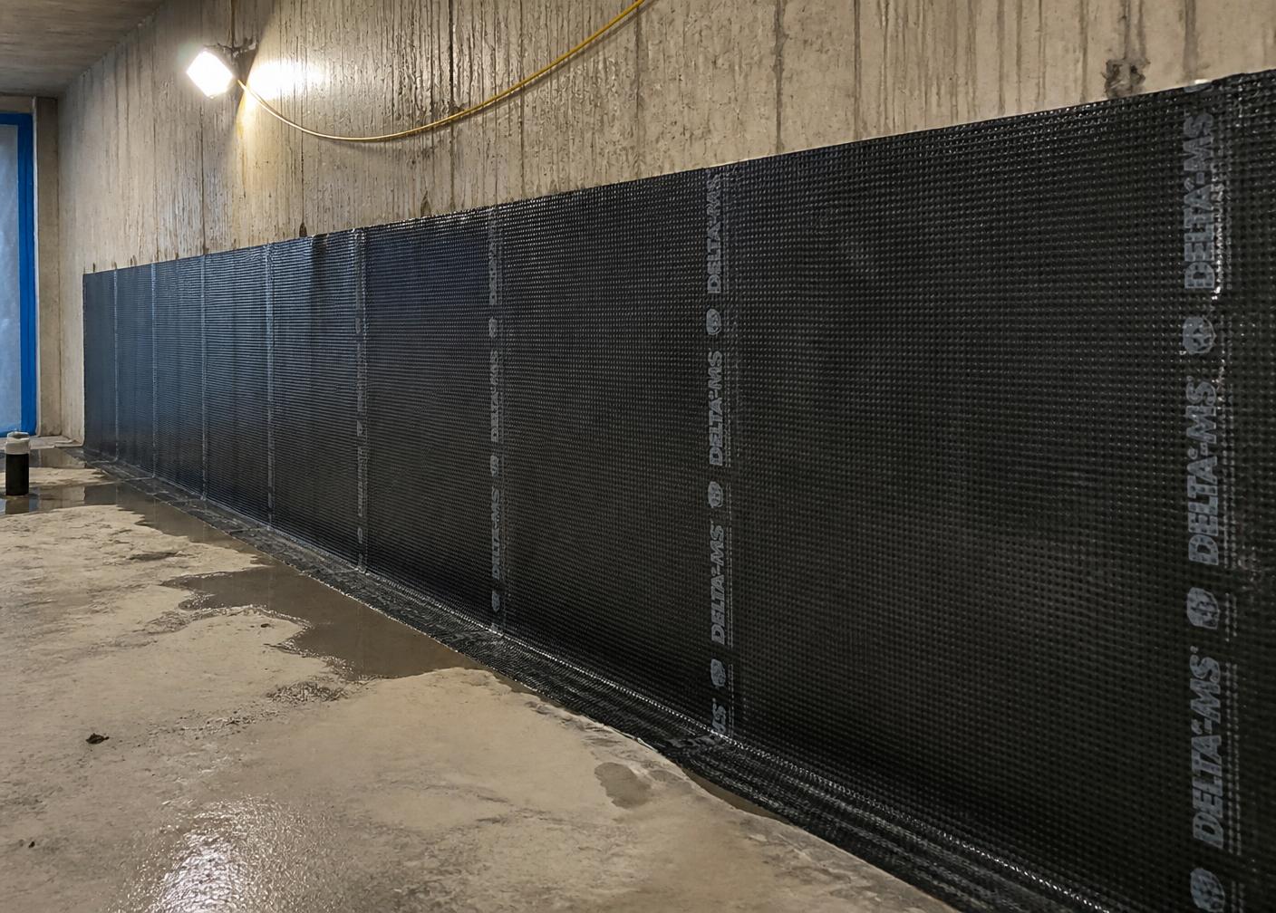 Waterproofing membrane installed against a below-ground concrete wall